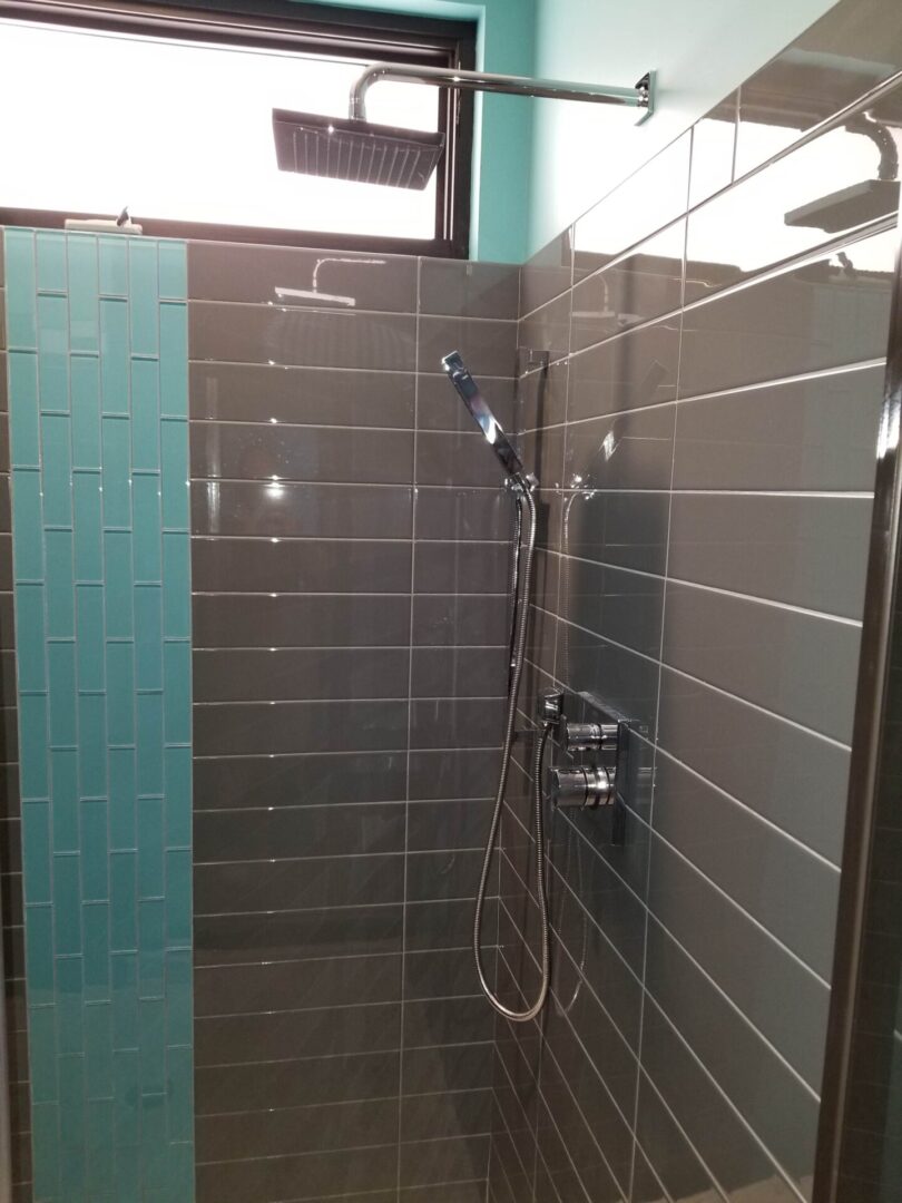 A stylish shower with gray and blue wall tiles